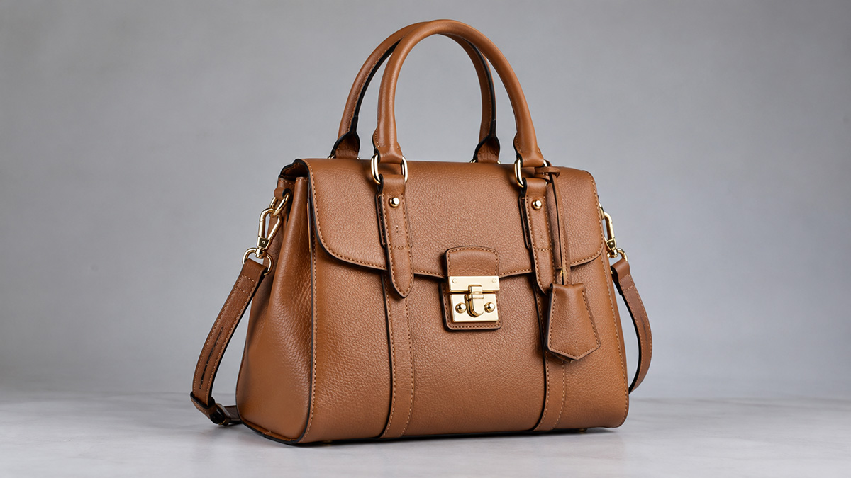 Brown leather handbag on a gray studio background before clipping path editing