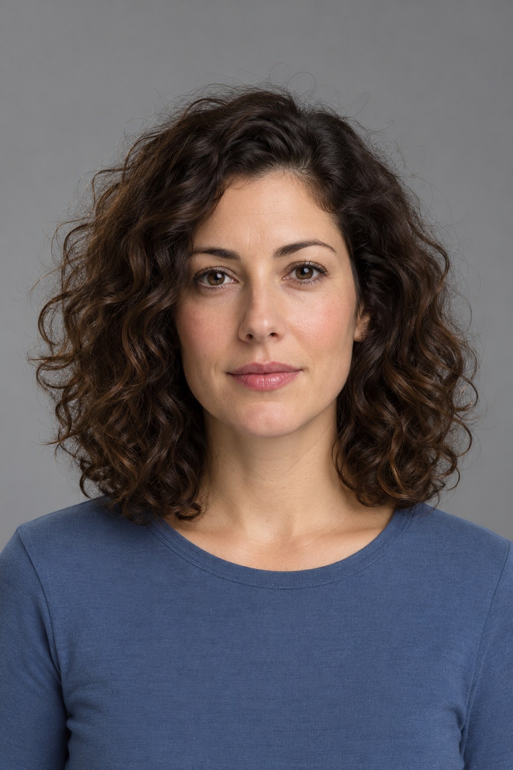Curly-haired portrait on grey before background removal — AI-generated demonstration